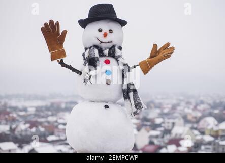 Pupazzo di neve in elegante cappello, sciarpa e guanti. Pupazzi di neve divertenti. Festa felice celebrazione. Foto Stock