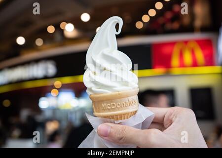 Bangkok, Thailandia - 28 Novembre 2020 : un uomo che tiene il cono alla vaniglia di McDonald davanti al ristorante. Foto Stock