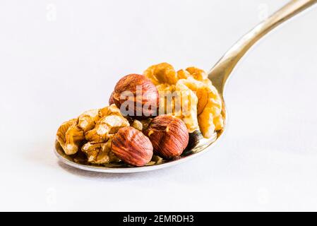 Primo piano di un cucchiaio di noci e nocciole su una tovaglia bianca, Londra, Regno Unito Foto Stock