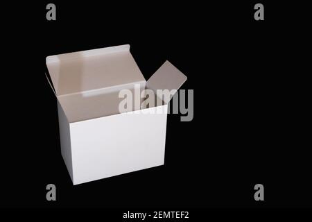 Scatola di imballaggio di carta bianca aperta isolata su sfondo nero con spazio di copia a destra Foto Stock