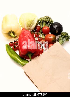 Peperoni con pomodori ciliegini e cavoli isolati su sfondo bianco. Broccoli, rafano nero e cavolo bianco con peperoncino e pomodoro in sacchetto eco. Set di verdure biologiche. Greengrocery concetto Foto Stock