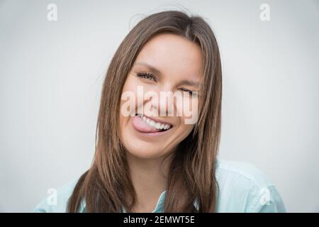 Allegra donna di affari felice che mostra la lingua e guardando la macchina fotografica. Positivo Foto Stock