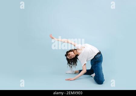 Ballerina artistica contemporanea in piedi sulle ginocchia, inarcando il suo corpo molto indietro Foto Stock