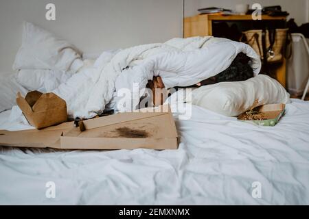 Donna depressa coperta in coperta che riposa a casa Foto Stock