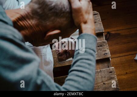 Vista ad alto angolo dell'uomo anziano che guarda nello specchio a. casa Foto Stock