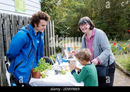 RSPB Stall con l'uomo che parla con la signora e il ragazzino che tiene in mano una scatola di uccelli, Apple Day Gillespie Ecology Park Foto Stock