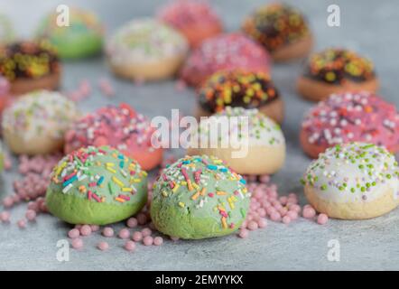 Biscotti colorati decorati con spruzzi su sfondo di marmo Foto Stock