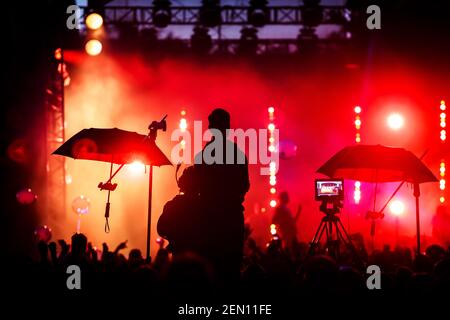 Team di equipaggi che lavorano per impostare e preparare la produzione per eventi di spettacolo o concerti musicali. Sagome nere. Foto Stock