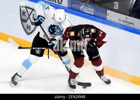 Riga, Lettonia. 25 Feb 2021. Reece Scarlett (R) di Dinamo riga vies con Ilya Usov di Dinamo Minsk durante la partita di hockey su ghiaccio della Kontinental Hockey League (KHL) del 2020-2021 tra Dinamo riga e Dinamo Minsk a riga, Lettonia, 25 febbraio 2021. Credit: Edijs Palens/Xinhua/Alamy Live News Foto Stock