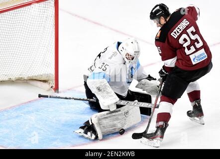 Riga, Lettonia. 25 Feb 2021. Alexei Kolosov (L), portiere di Dinamo Minsk, cerca di risparmiare durante la partita di hockey su ghiaccio della Kontinental Hockey League (KHL) del 2020-2021 tra Dinamo riga e Dinamo Minsk a riga, Lettonia, 25 febbraio 2021. Credit: Edijs Palens/Xinhua/Alamy Live News Foto Stock