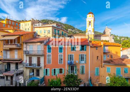 Villaggio colorato di Villefranche-sur-Mer, Francia e la torre dell'orologio della chiesa gialla di Saint Michel Chiesa nella città balneare sulla Costa Azzurra. Foto Stock