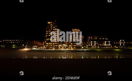 Umea, Norrland Svezia - 10 febbraio 2021: Case alte sull'altro lato del fiume Foto Stock