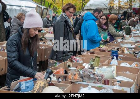 Gli acquirenti navigano al Flohmarkt am Mauerpark (mercato delle pulci domenicali a Mauerpark) Berlino, Germania. Il Muro di Berlino fa parte del confine del mercato Foto Stock