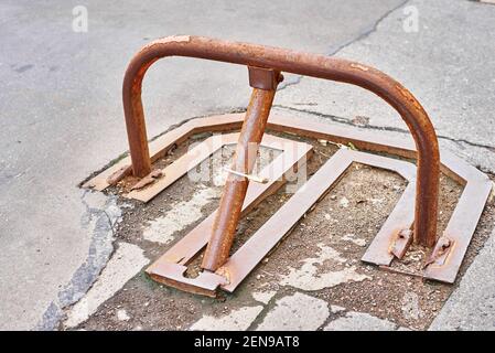 Barriera di parcheggio manuale in metallo rosso con blocco. Dispositivo di  blocco della posizione di parcheggio. Barriera di parcheggio installata.  Una barriera pieghevole impedisce il vehi Foto stock - Alamy