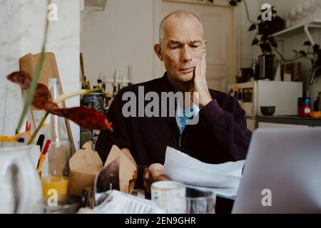 Uomo d'affari che legge documento cartaceo in soggiorno Foto Stock