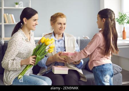 Felice nonna che ottiene fiori e regali dalla sua famiglia amorevole Il giorno della Madre Foto Stock