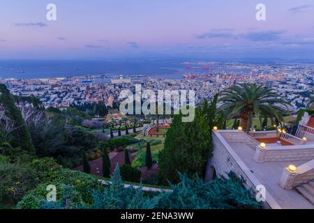 Vista al tramonto del Santuario Bahai e dei giardini, con il centro e il porto, a Haifa, Israele settentrionale Foto Stock