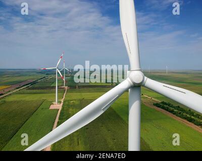 Generazione di energia elettrica turbina eolica in campo verde. Aerogeneratore eolico Farm vista aerea. Turbine eoliche in campagna. Foto Stock