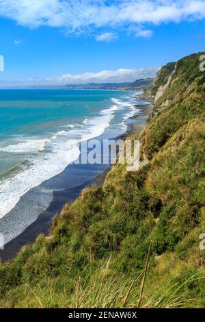 La costa a Whitecliffs, Taranaki Regione, Nuova Zelanda. Panini pesanti da surf a riva sulla spiaggia di sabbia nera Foto Stock