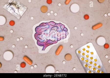 Trattamento e prevenzione delle malattie cerebrali con una varietà di pillole: Antibiotici, vitamine, antidolorifici, antidepressivi. Disegno del cervello intorno ai tablet su Foto Stock
