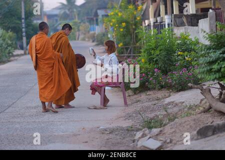 Kalasin, Thailandia - 22 febbraio 2021 : la gente sta mettendo il cibo nei monaci al mattino. Foto Stock