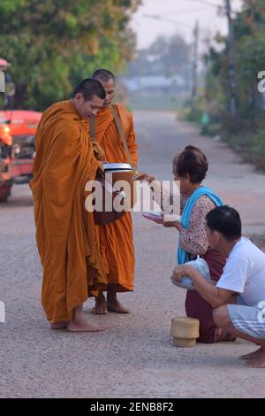 Kalasin, Thailandia - 22 febbraio 2021 : la gente sta mettendo il cibo nei monaci al mattino. Foto Stock