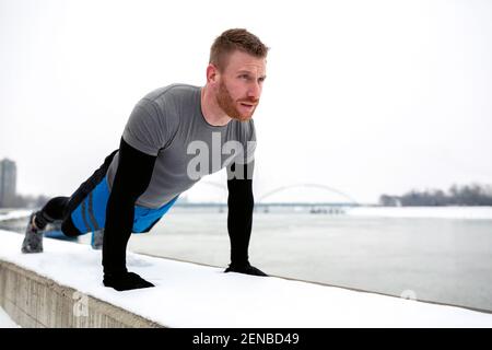 Spingi verso l'alto sul muro di riva vicino al freddo Danubio fiume Foto Stock
