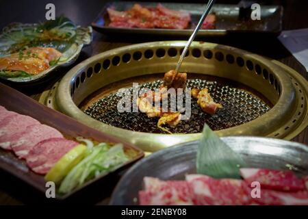 Barbecue giapponese su una stufa Chacoal caldo. Grigliare il pollo sulla padella. Foto Stock