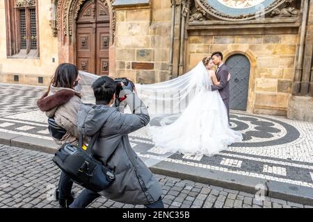 Praga, Repubblica Ceca - 20 gennaio 2020: Il fotografo cinese scatta foto di una coppia di nozze. Foto Stock