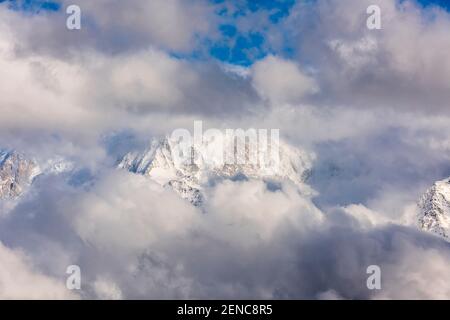 Massiccio del Monte Bianco immerso nelle nuvole in una giornata invernale. Catena del massiccio del Monte Bianco vista dal lato francese. Foto Stock