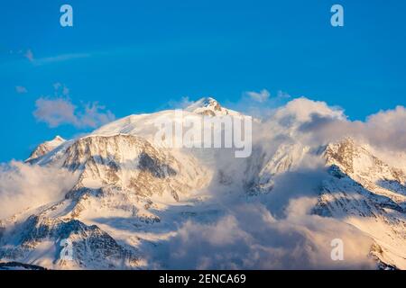 Massiccio del Monte Bianco immerso nelle nuvole in una giornata invernale. Catena del massiccio del Monte Bianco vista dal lato francese. Foto Stock