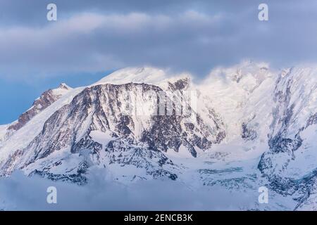 Massiccio del Monte Bianco immerso nelle nuvole in una giornata invernale. Catena del massiccio del Monte Bianco vista dal lato francese. Foto Stock