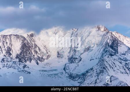 Massiccio del Monte Bianco immerso nelle nuvole in una giornata invernale. Catena del massiccio del Monte Bianco vista dal lato francese. Foto Stock