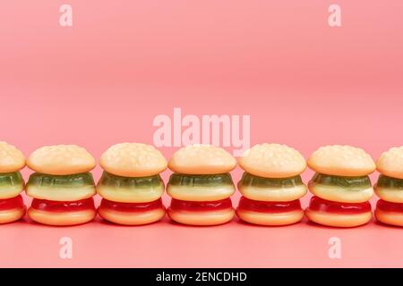 Hamburger caramelle colorate su sfondo rosa. Concetto di cibo minimo. Foto Stock