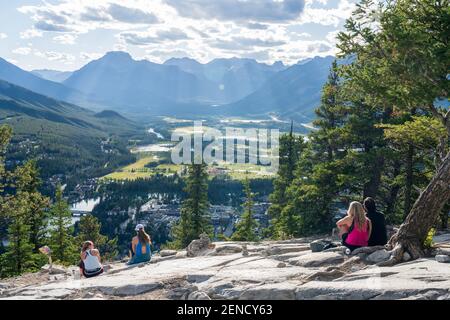 Turisti che si affacciano sulla città di Banff dalla cima del Tunnel Mountain Trail in estate soleggiato giorno. Banff National Park, Canadian Rockies. Banff, Alberta, Foto Stock