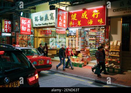 Hong Kong, Cina. Scena dello shopping notturno in Wing Lok Street, Sheung WAN. Negozi tradizionali. Foto Stock