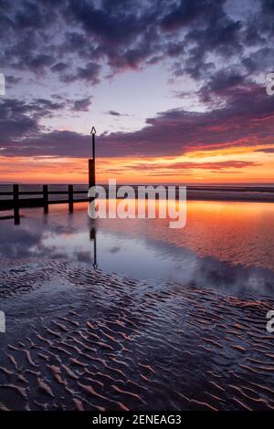 Tramonto sulla spiaggia di Rhyl a bassa marea a nord Costa del Galles Foto Stock
