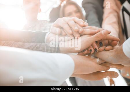 primo piano. un gruppo di giovani uomini d'affari che formano una torre dalle loro mani Foto Stock