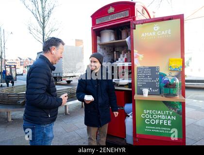 Londra, Regno Unito. 26 Febbraio 2021 UNA cabina telefonica in King Street Twickenham si è convertita ed ha aperto questa settimana come un chiosco caffè / bar / stand. Amar Cafe noleggiare lo stand e hanno installato tutto ciò che è necessario per barista fatto specialità caffè colombiano a 100 metri dal fiume Tamigi. Carlos era il barista e si prendono solo pagamenti con carta di credito. La cabina ha l'alimentazione che esisteva già da quando era un telefono a pagamento e l'acqua è imbottigliata e portata sul posto. Hanno cabine simili a Chiswick e Greenwich. Andrew Fosker / Alamy Live News Foto Stock