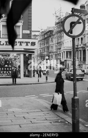 UK, West London, Notting Hill, 1973. Rundown e faticosamente grandi case a quattro piani stanno iniziando ad essere restaurate e ridecorate. Elgin Crescent incontra Portobello Road. Colville Terrace oposite con impalcature su case in riparazione. Foto Stock