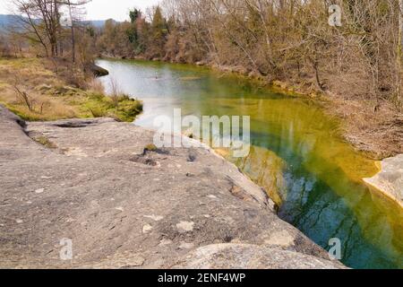 Vista panoramica del fiume Merles attraversando una lussureggiante foresta piena di pini bianchi e rossi in una soleggiata giornata invernale. Sta. Maria de Merles, Catalogna, Spagna Foto Stock