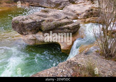 Vista di una piccola cascata che riempie una delle numerose piscine trovate lungo il percorso del fiume Merles. Sta. Maria de Merles, Catalogna, Spagna Foto Stock