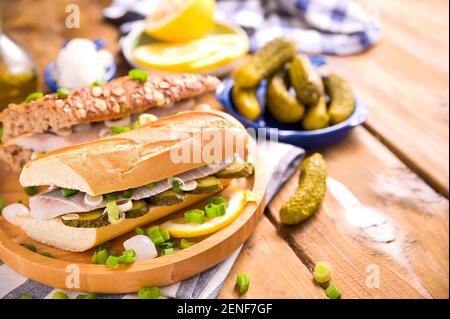 Aringhe olandesi in un panino. Brindate con aringhe olandesi, cipolle, sottaceti. Antipasto rustico tradizionale con frutti di mare. Cibo popolare nei Paesi Bassi. Spazio di copia Foto Stock