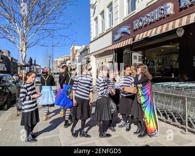 I bambini ebrei celebrano la festa ebraica di Purim (Festival dei lotti) in Golders Green - una grande comunità ebraica nel nord-ovest di Londra. Le ragazze sono vestite in bianco e nero come ladri e alcune come pagliacci colorati. Londra, Regno Unito. 26 febbraio 2021. Foto Stock