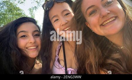 Selfie ritratto di tre ragazze adolescenti multiculturali felici di differenti primo piano della gara Foto Stock