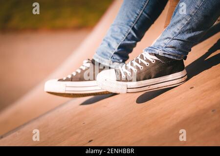 Un primo piano di una persona in un paio di jeans e un paio di scarpe da ponte allacciate Foto Stock