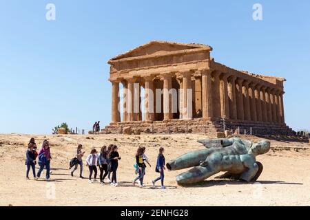 Italia, Sicilia, Agrigento, Valle dei Templi, Tempio della Concordia (V secolo a.C.), turisti e statua di Icaro Foto Stock