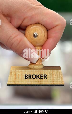 Holzstempel, Hand mit Stempel, Frauenhand, Aufschrift: Broker Foto Stock