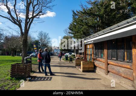 Code socialmente distanziate di persone che ordinano bevande al Sunny Hill Cafe, una caffetteria a Sunny Hill Park, Hendon. Inizio di un weekend soleggiato con cielo blu.. Regno Unito Meteo. Londra, Regno Unito. 26 febbraio 2021. Foto Stock