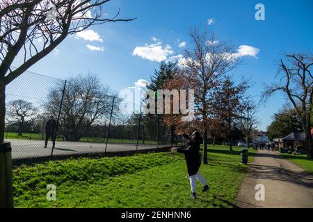 Una coppia che si diverse a giocare una partita di palla in un parco locale nel nord di Londra. Cielo soleggiato blu nel Sunny Hill Park, Hendon. Foto Stock